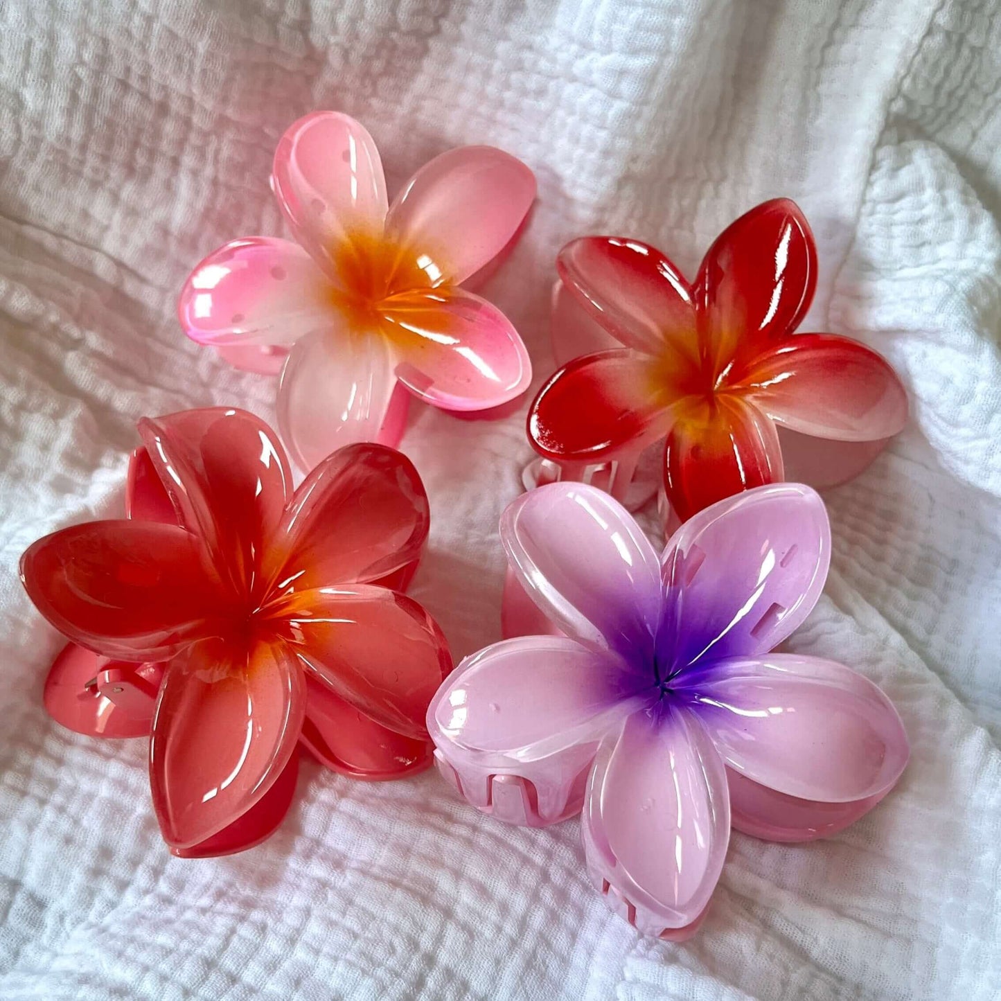 assortiment de pinces à cheveux en forme de fleurs, de couleurs rose, violette, et rouge